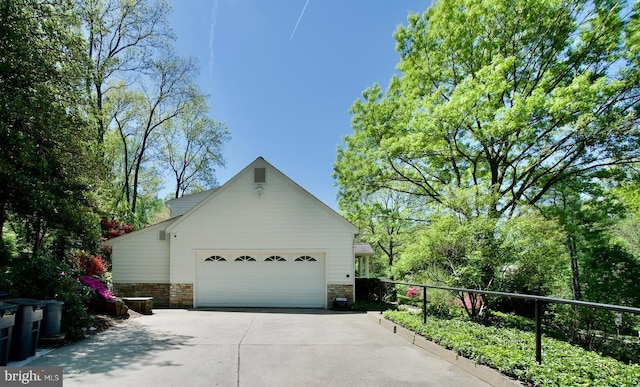 view of home's exterior featuring concrete driveway and stone siding