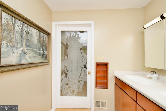 bathroom with double vanity, visible vents, and a sink