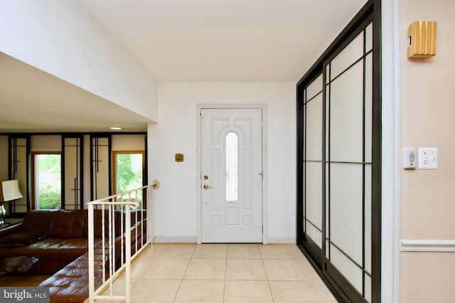 foyer featuring baseboards and light tile patterned floors