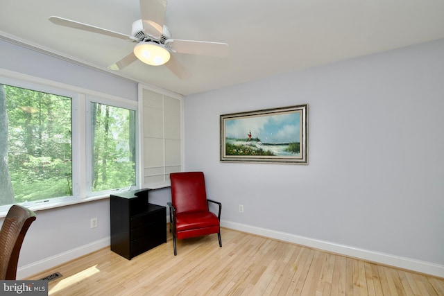 sitting room with ceiling fan, visible vents, wood-type flooring, and baseboards