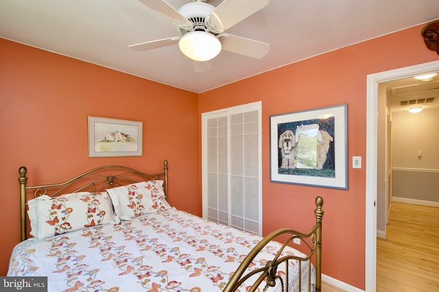 bedroom with baseboards, visible vents, wood finished floors, and a ceiling fan