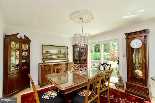 dining area with ornamental molding, light wood finished floors, and a notable chandelier