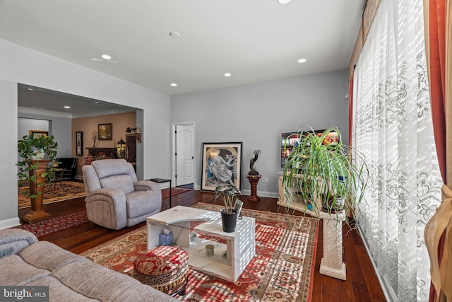living room featuring baseboards, recessed lighting, and wood finished floors