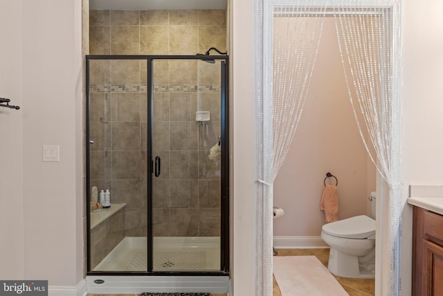 full bath with tile patterned flooring, vanity, toilet, baseboards, and a shower stall