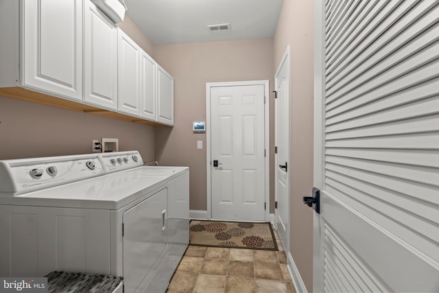 clothes washing area with cabinet space, washer and dryer, stone finish floor, baseboards, and visible vents