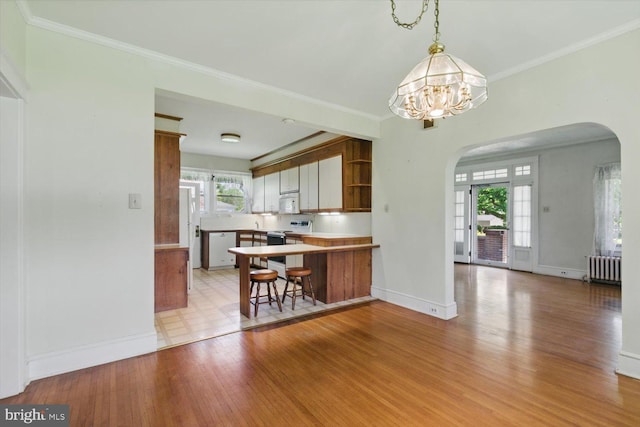 103 Pleasure Rd, Lancaster, PA 17601 - kitchen with radiator heating unit, arched walkways, a peninsula, and white appliances