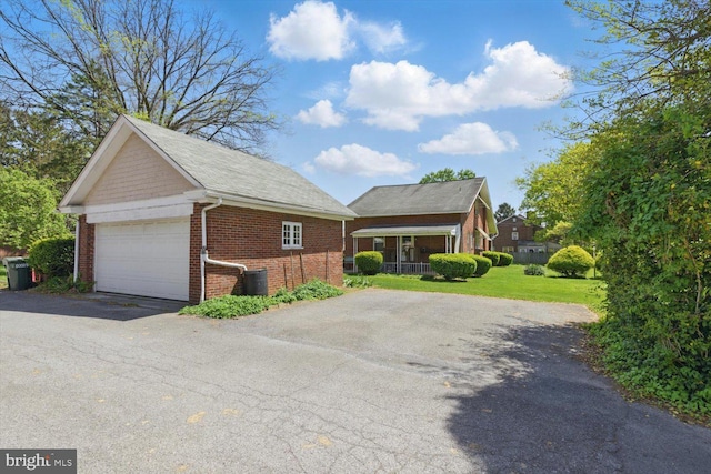 103 Pleasure Rd, Lancaster, PA 17601 - view of property exterior featuring a garage, aphalt driveway, brick siding, an outbuilding, and a yard