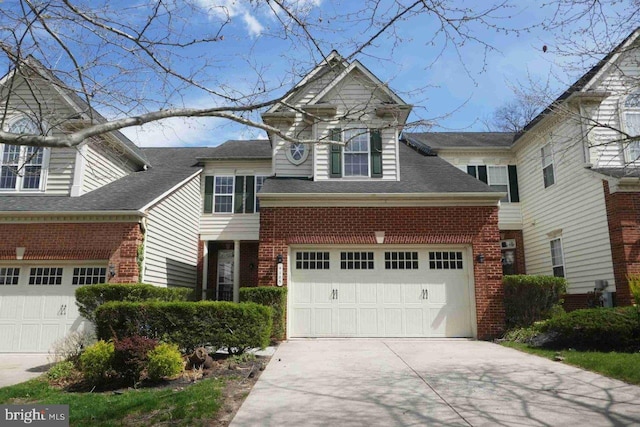 traditional-style house featuring a garage, driveway, and brick siding