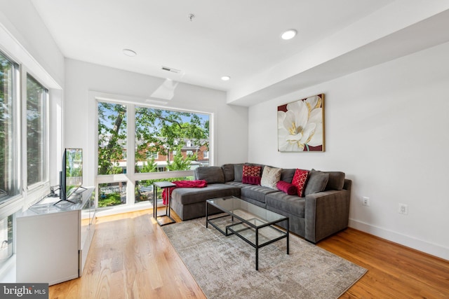 living room featuring recessed lighting, baseboards, visible vents, and light wood-style flooring