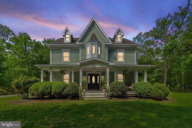 view of front of house with a porch and a lawn