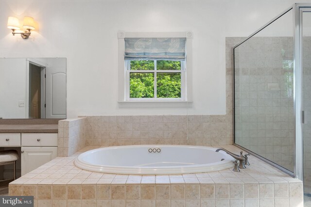 bathroom featuring a tile shower and a bath