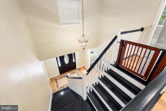 staircase with baseboards and a high ceiling