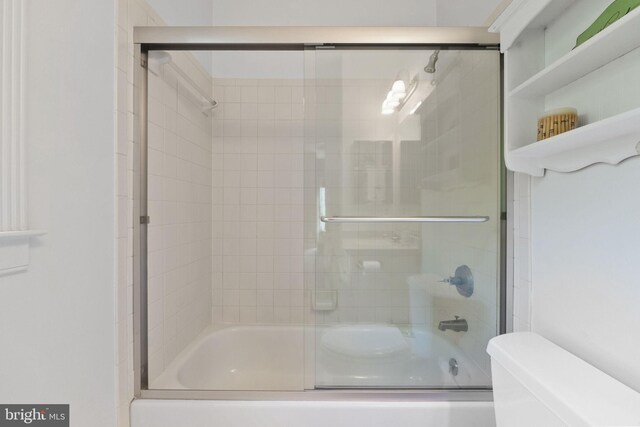 full bathroom with enclosed tub / shower combo and toilet