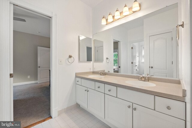 full bathroom with a sink, baseboards, tile patterned floors, and double vanity