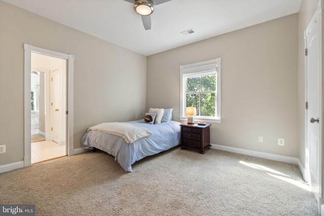 bedroom with ceiling fan, visible vents, baseboards, ensuite bathroom, and carpet