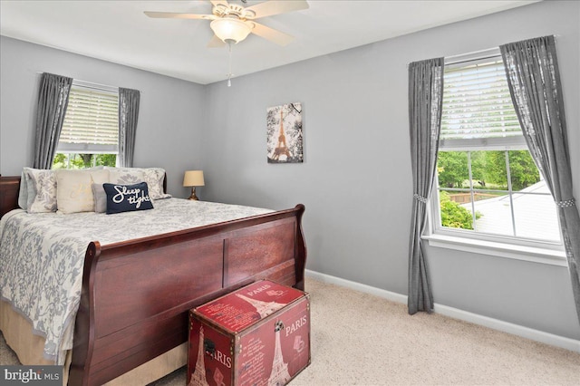carpeted bedroom featuring multiple windows, baseboards, and ceiling fan