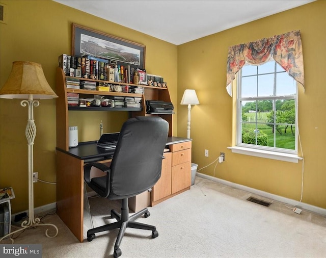 office space with healthy amount of natural light, light colored carpet, and baseboards