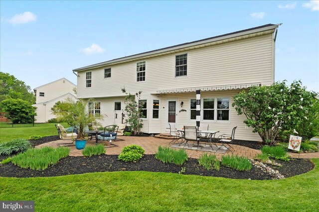 back of property with a patio area and a lawn