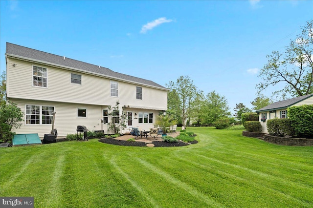 rear view of property with a patio area and a yard