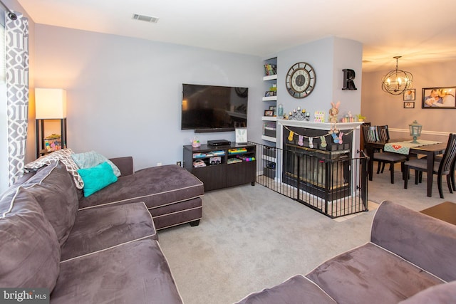 living area featuring a chandelier and carpet flooring