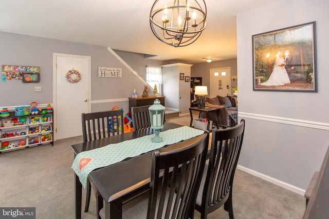 carpeted dining area featuring a chandelier and baseboards