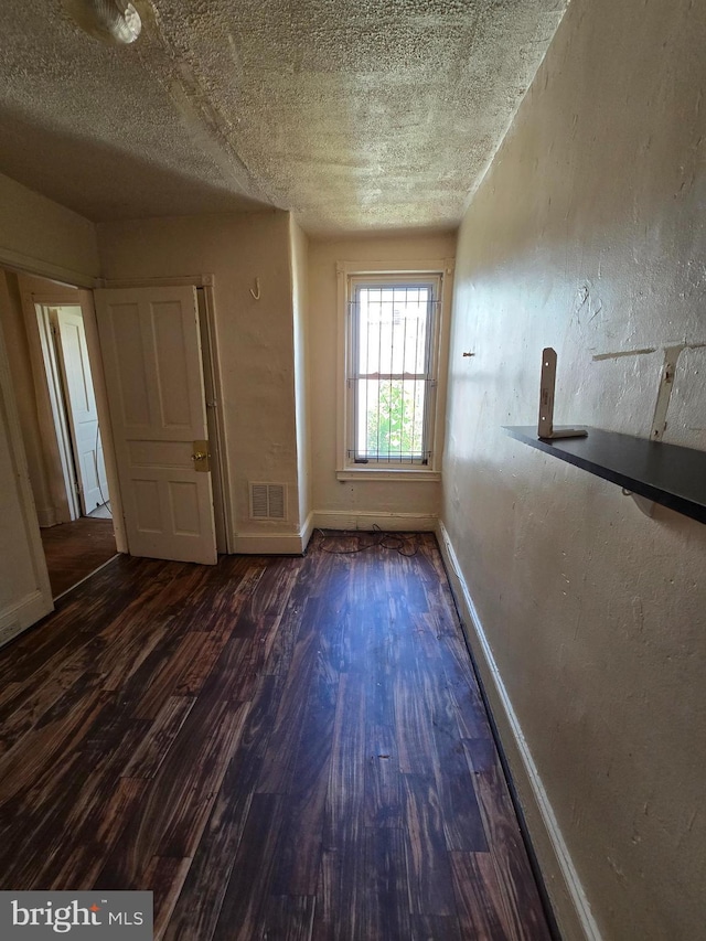 5133 Reno St, Philadelphia, PA 19139 - empty room featuring baseboards, visible vents, a textured ceiling, and dark wood-style flooring