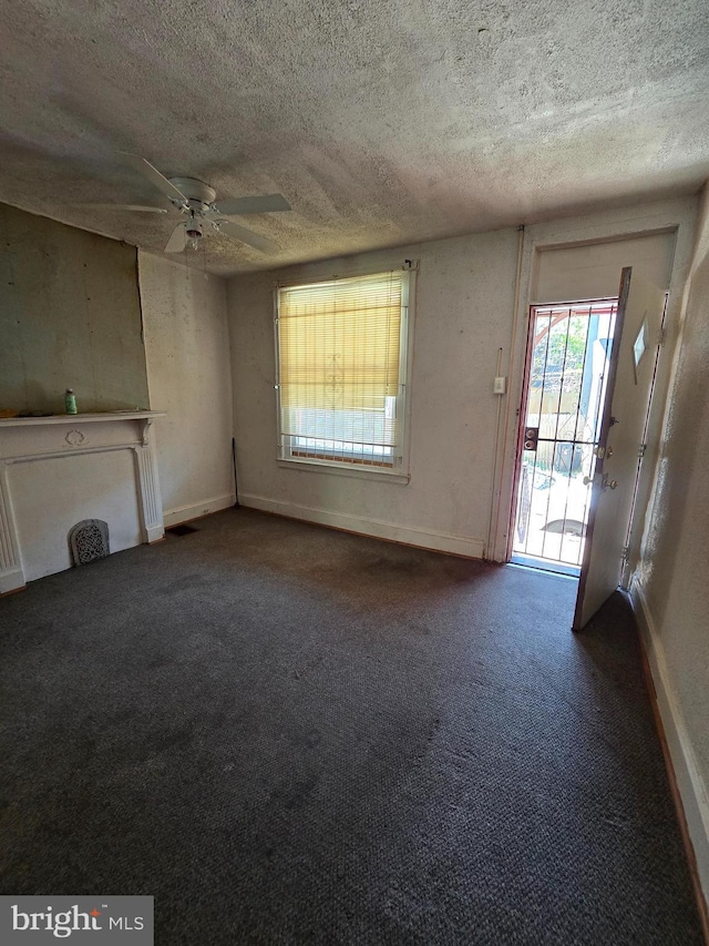 5133 Reno St, Philadelphia, PA 19139 - unfurnished living room featuring baseboards, ceiling fan, a textured ceiling, and carpet floors