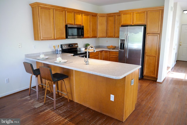 2725 Shelburne Rd, Downingtown, PA 19335 - kitchen featuring a peninsula, light countertops, brown cabinets, a sink, and stainless steel appliances