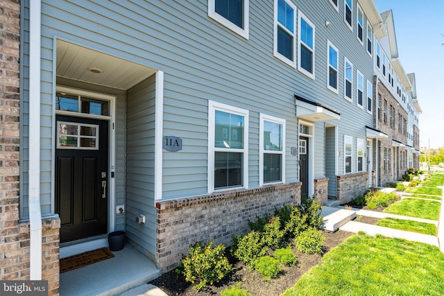 property entrance featuring brick siding