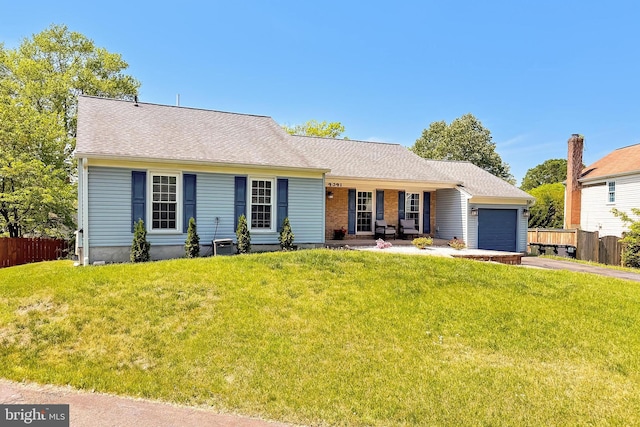 single story home with an attached garage, fence, driveway, and a front lawn