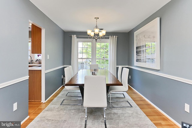 dining space with an inviting chandelier and light wood-type flooring