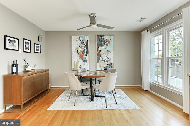 dining area with baseboards, a ceiling fan, wood finished floors, and visible vents