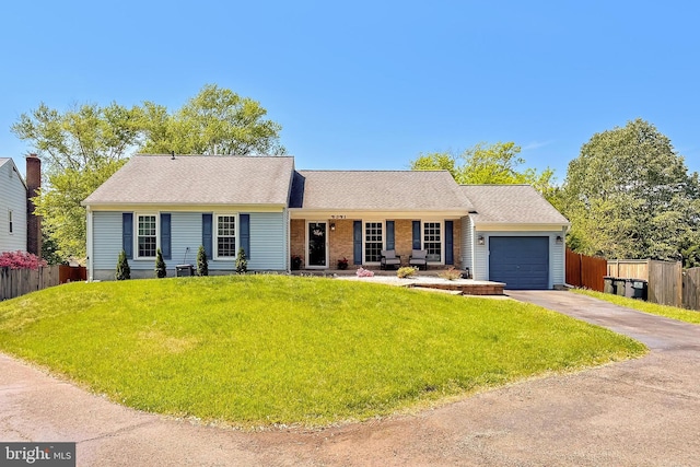 ranch-style home with fence, a front lawn, driveway, and a garage