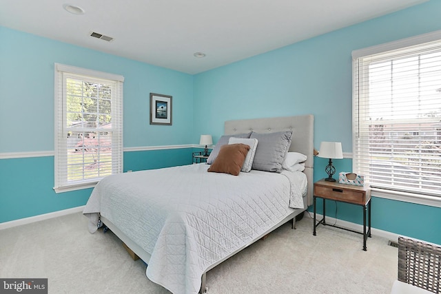 carpeted bedroom featuring visible vents and baseboards