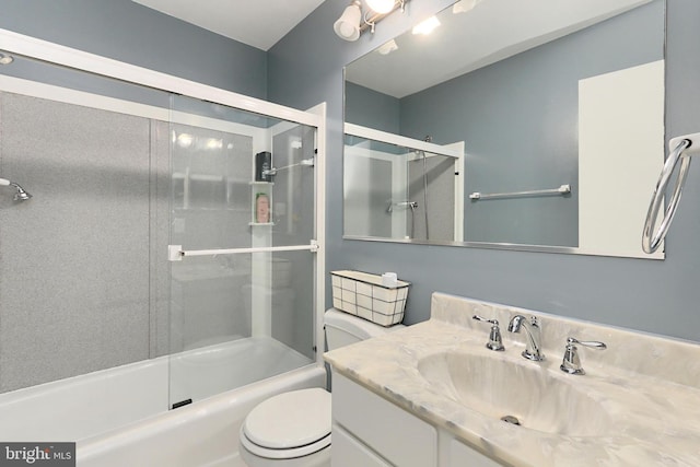 full bathroom featuring vanity, enclosed tub / shower combo, and toilet