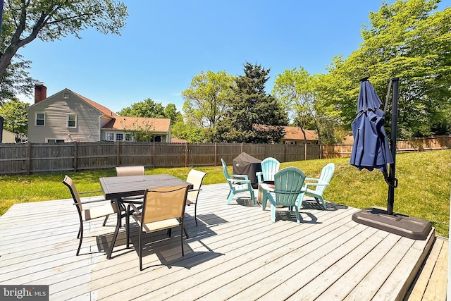 wooden deck with a yard, outdoor dining space, and a fenced backyard