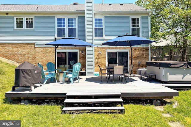 back of property with brick siding, a deck, fence, and outdoor dining area