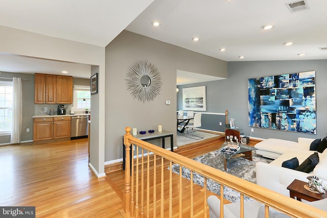 living room featuring recessed lighting, baseboards, visible vents, and light wood finished floors
