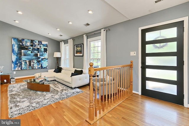living room with recessed lighting, visible vents, wood finished floors, and lofted ceiling