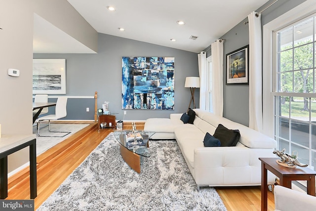 living room with recessed lighting, vaulted ceiling, plenty of natural light, and wood finished floors