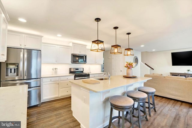 1265 Dietz Rd, Red Lion, PA 17356 - kitchen featuring a sink, stainless steel appliances, wood finished floors, white cabinets, and open floor plan