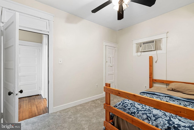 bedroom featuring a ceiling fan, baseboards, a wall mounted AC, and carpet