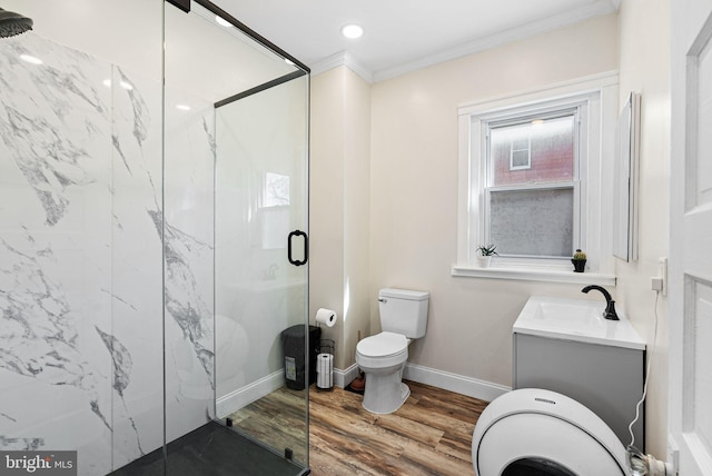 full bathroom featuring vanity, toilet, a marble finish shower, wood finished floors, and ornamental molding