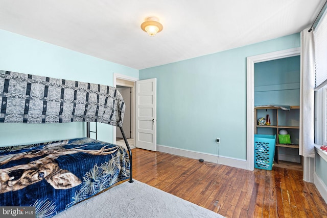 bedroom with wood-type flooring, baseboards, and multiple windows