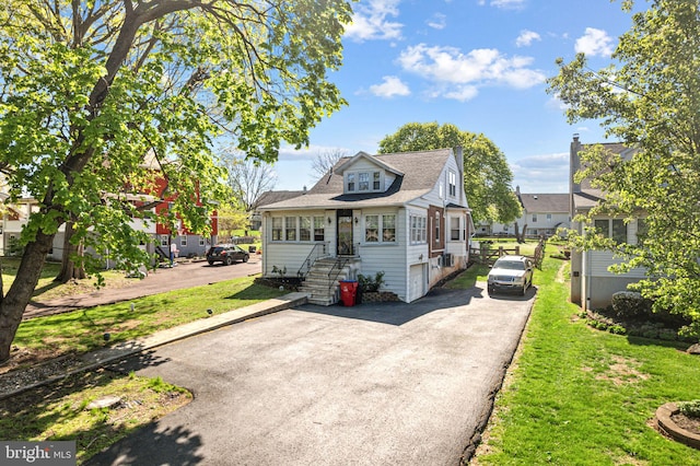 bungalow with a front lawn and aphalt driveway