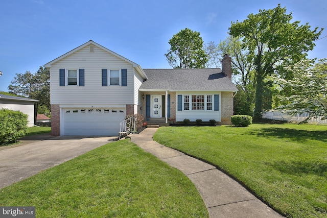 tri-level home featuring a garage, a chimney, driveway, and brick siding