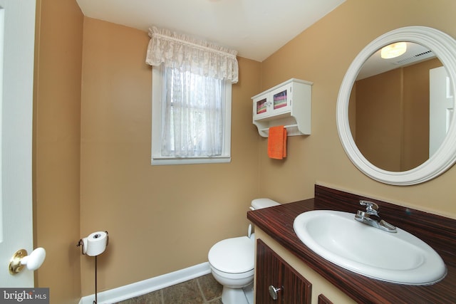 bathroom with tile patterned flooring, vanity, toilet, baseboards, and visible vents