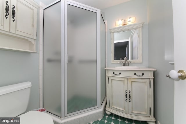 bathroom with vanity, a stall shower, and toilet