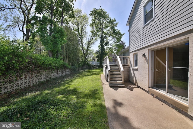 view of yard with stairs, a fenced backyard, and a patio area