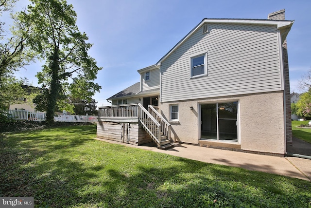 back of house featuring a wooden deck, fence, a yard, stairs, and stucco siding